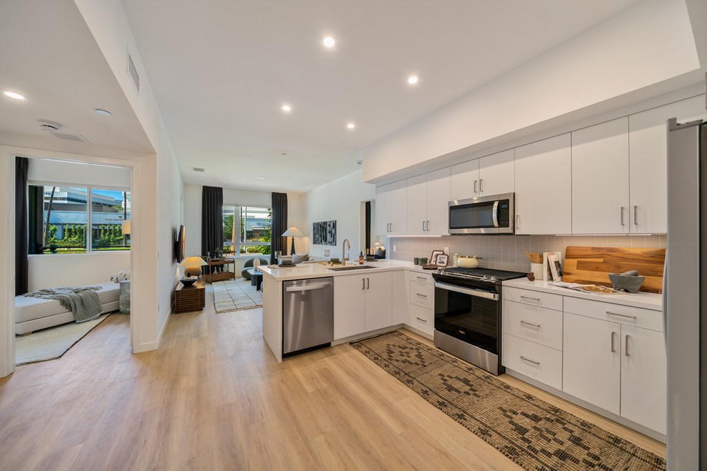 A modern kitchen with white cabinets and stainless steel appliances.