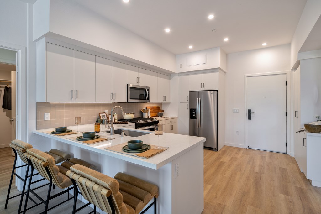 A modern kitchen with a white island and stainless steel appliances.
