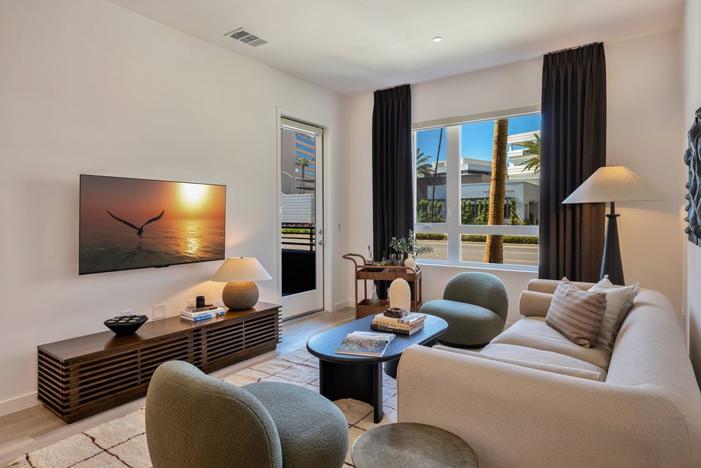 A living room with a white couch, a coffee table, and a painting on the wall.