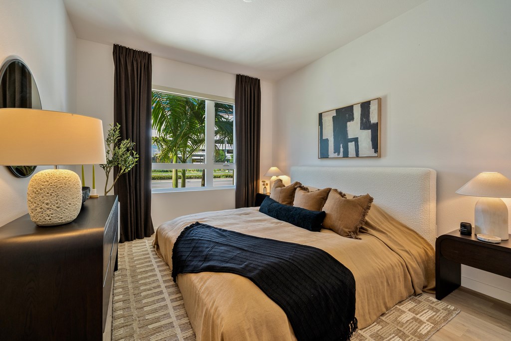 A bedroom with a large bed and a painting on the wall.
