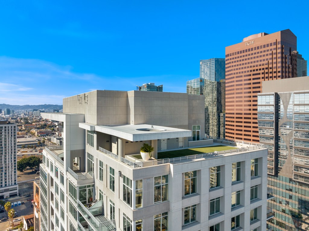 A modern building with a flat roof and large windows is surrounded by other buildings.