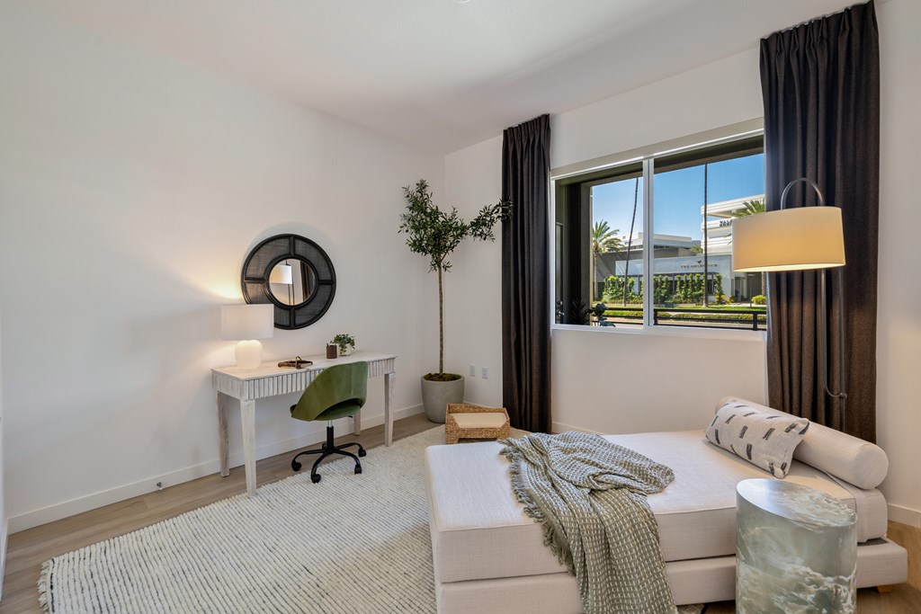 A bedroom with a bed, desk, and chair.