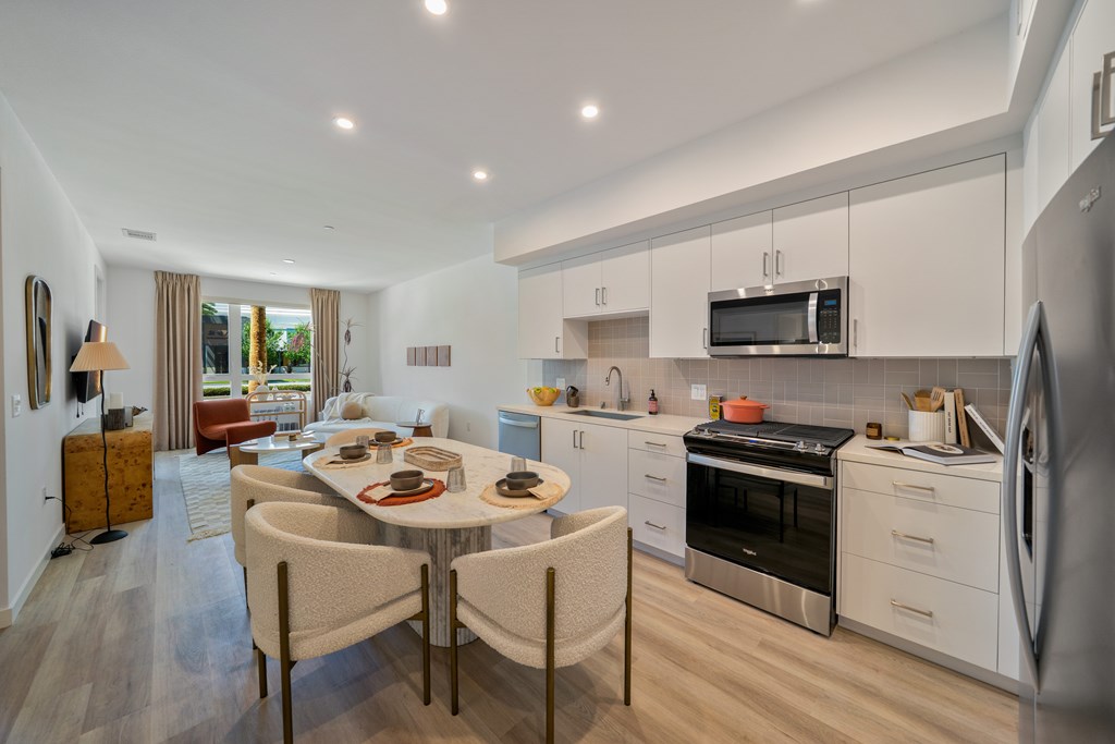 A modern kitchen with a dining table set for two.