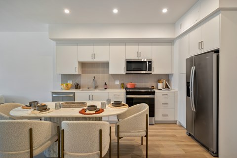 A modern kitchen with a dining table set for four.