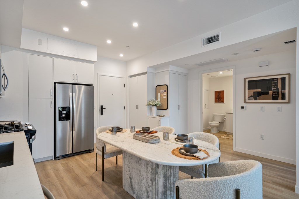 A modern kitchen with a dining table and chairs.