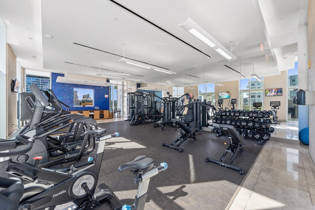A gym with treadmills, stationary bikes, and other exercise equipment.