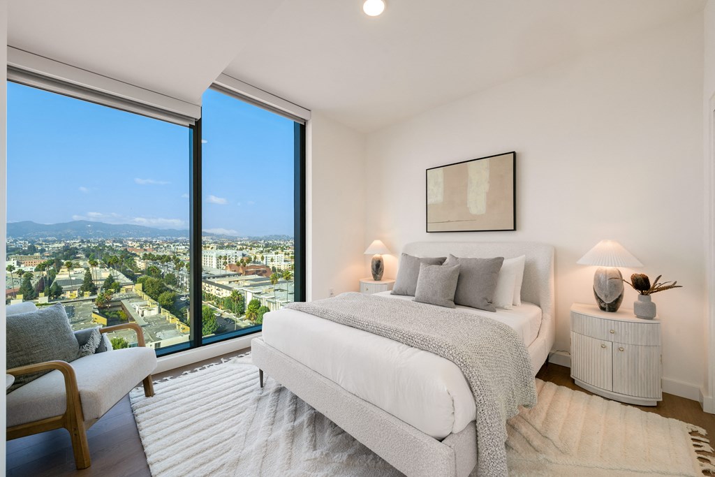 a bedroom with a bed and a view of the city