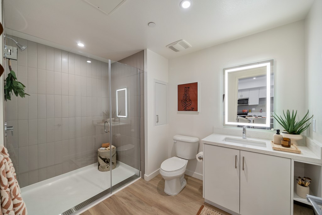 A bathroom with a toilet, sink, and shower.