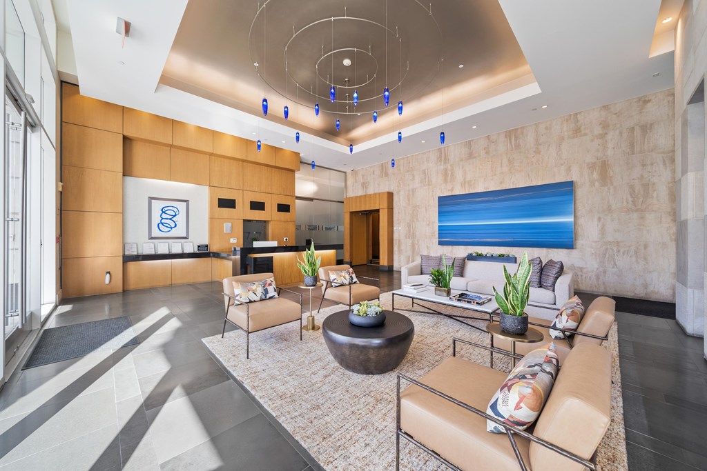 A modern living room with a large sofa, a coffee table, and a painting on the wall.
