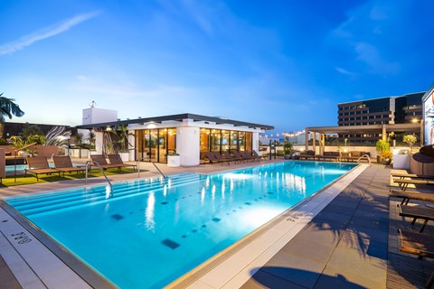 A large swimming pool in the foreground with a building in the background.