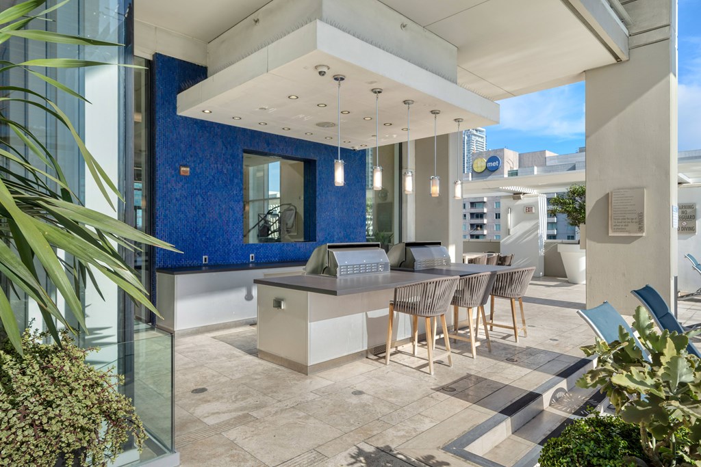 A modern outdoor kitchen area with a dining table and chairs.