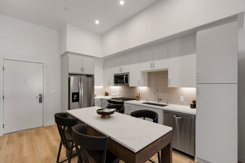 A modern kitchen with a dining table and chairs.