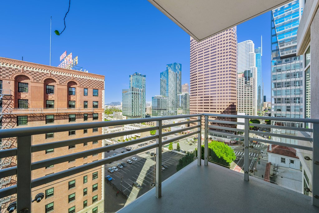 A balcony overlooks a cityscape with a mix of modern and older buildings.