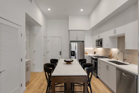 A modern kitchen with a dining table and chairs.