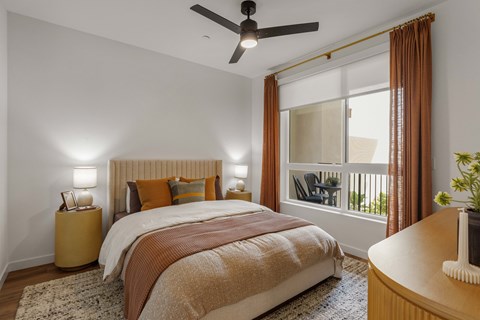 A bedroom with a large bed and a ceiling fan.