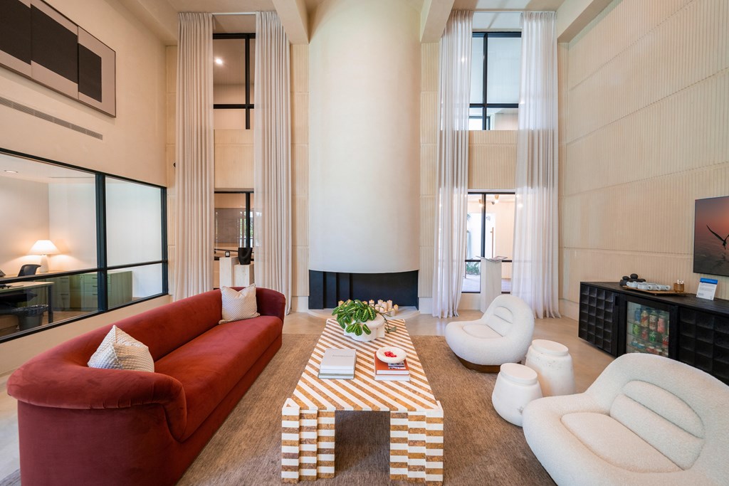 A living room with a red couch and a striped coffee table.