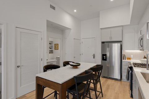 A modern kitchen with a table and chairs.