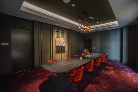 A conference room with a long table and chairs.