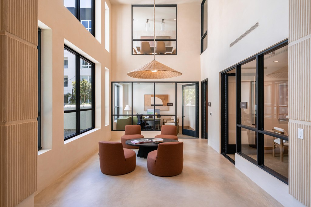 A modern living room with a large window and a dining table.