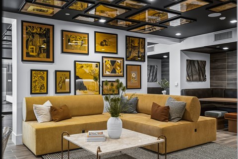 A living room with a yellow couch and a coffee table.