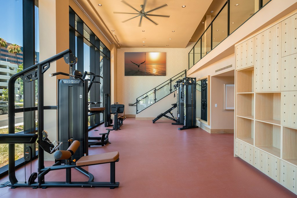 A gym with a red floor and a ceiling fan.