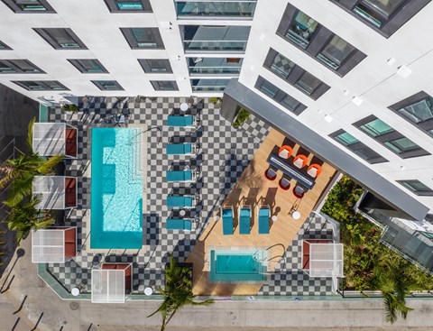 a rendering of the pool area of a hotel with a swimming pool and lounge chairs