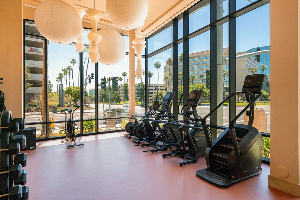 A gym with exercise equipment and a view of the city.