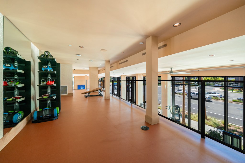 A long hallway with a bench and a row of shoes on the left.
