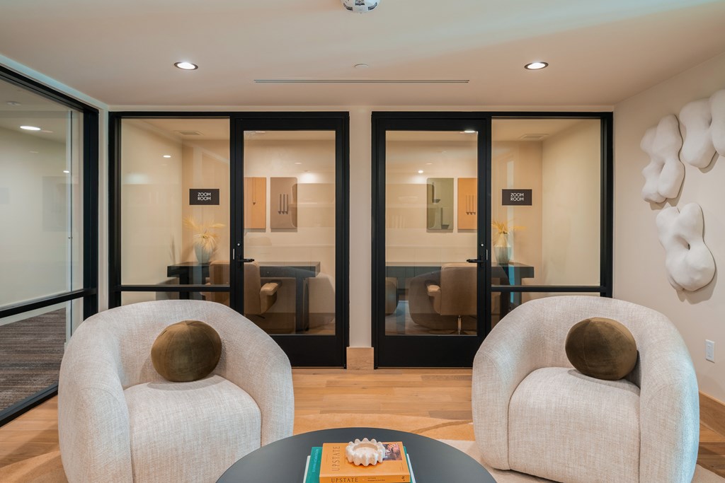 Two chairs and a table are in a room with glass doors.