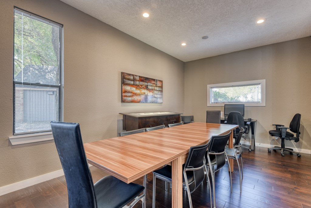 a meeting room with a large wooden table and chairs