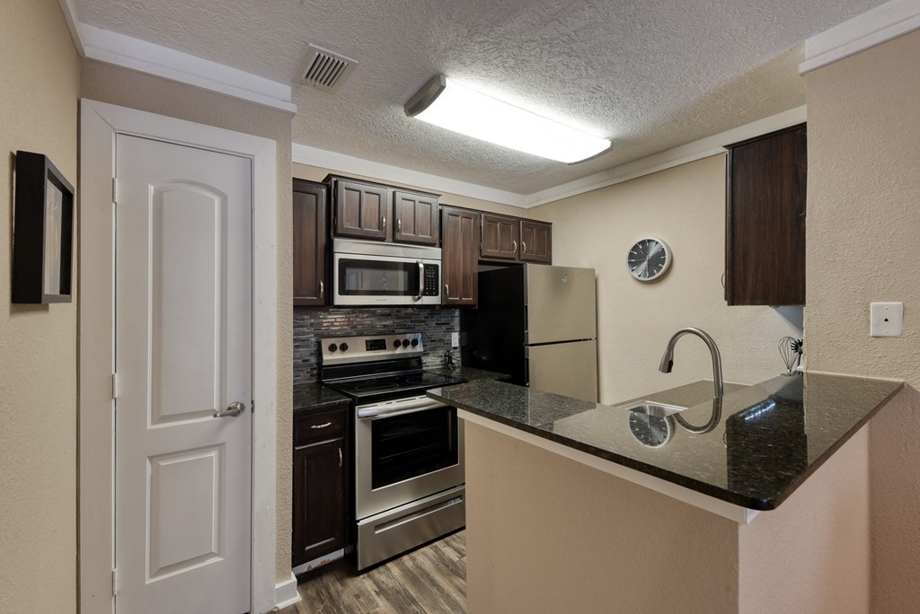 a kitchen with a granite counter top and stainless steel appliances