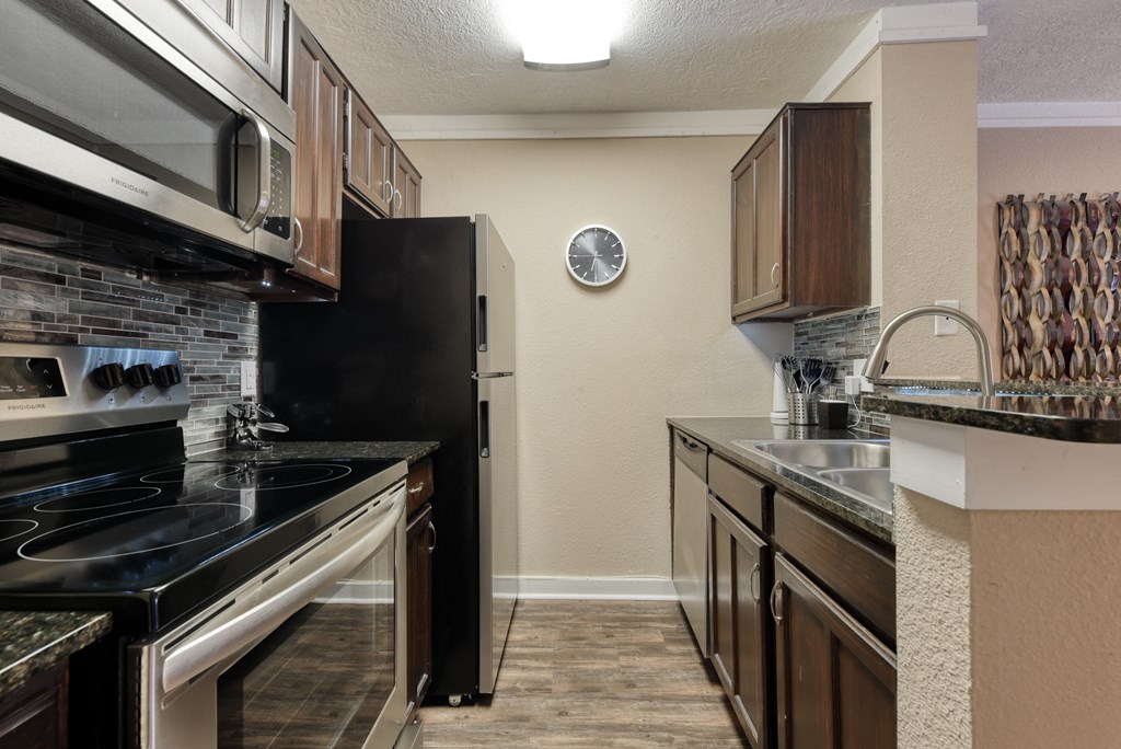 a kitchen with wooden cabinets and black appliances