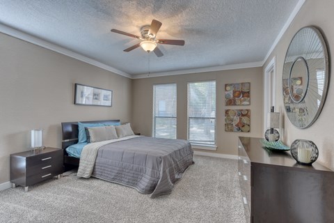 a bedroom with a bed and a ceiling fan