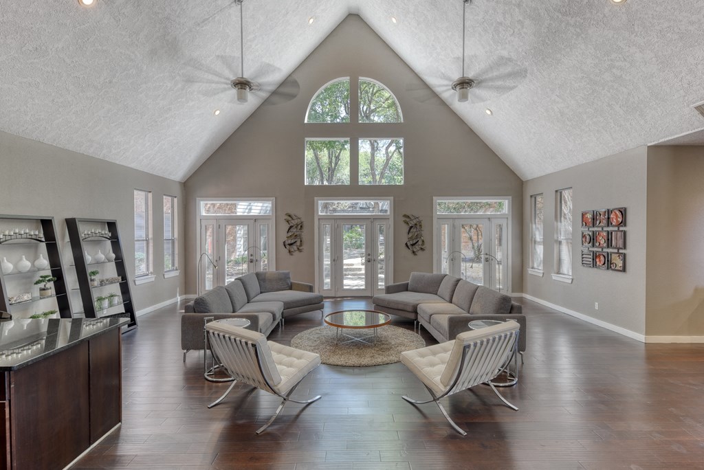 a living room with a vaulted ceiling and large windows