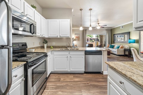 A kitchen with white cabinets and a stainless steel refrigerator.