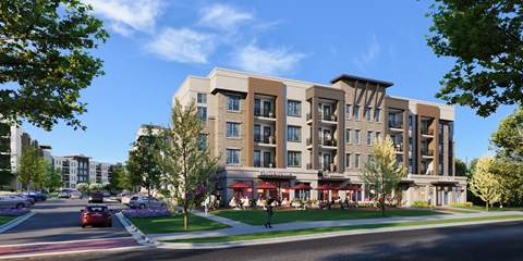 A modern apartment building with a parking lot in front.