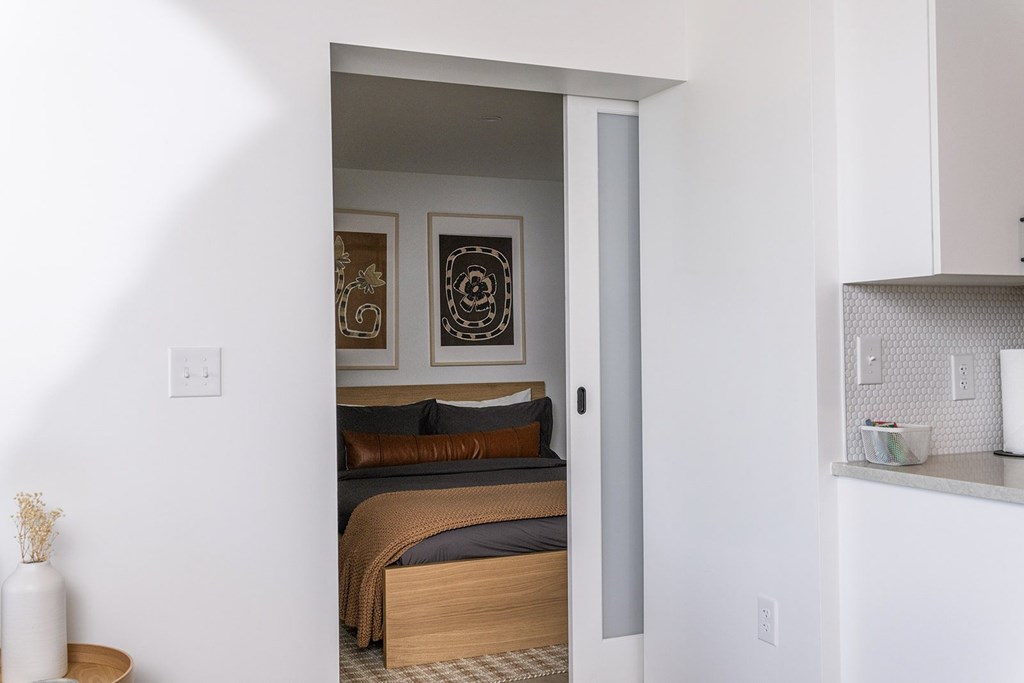 A bedroom with a bed, a nightstand, and a picture on the wall.