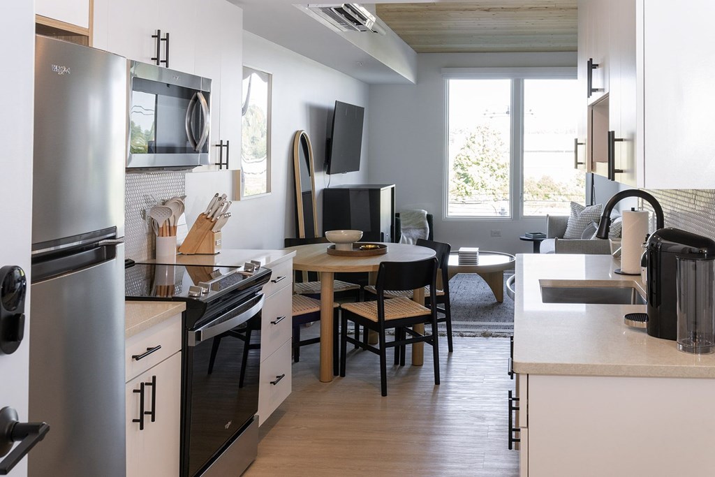 A modern kitchen with a dining table and chairs.