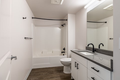 A white bathroom with a toilet, sink, and bathtub.