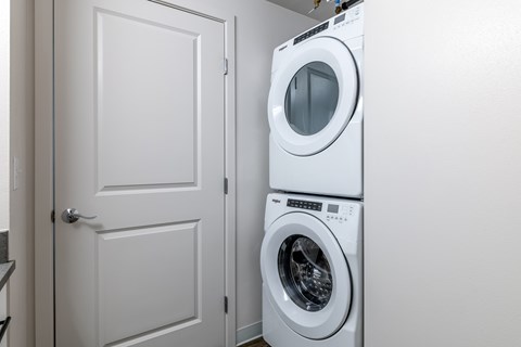 A white door is next to a white washing machine.