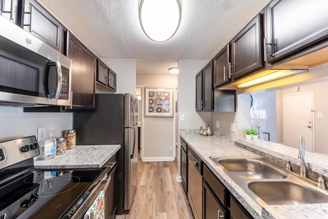 A kitchen with black cabinets and stainless steel appliances.