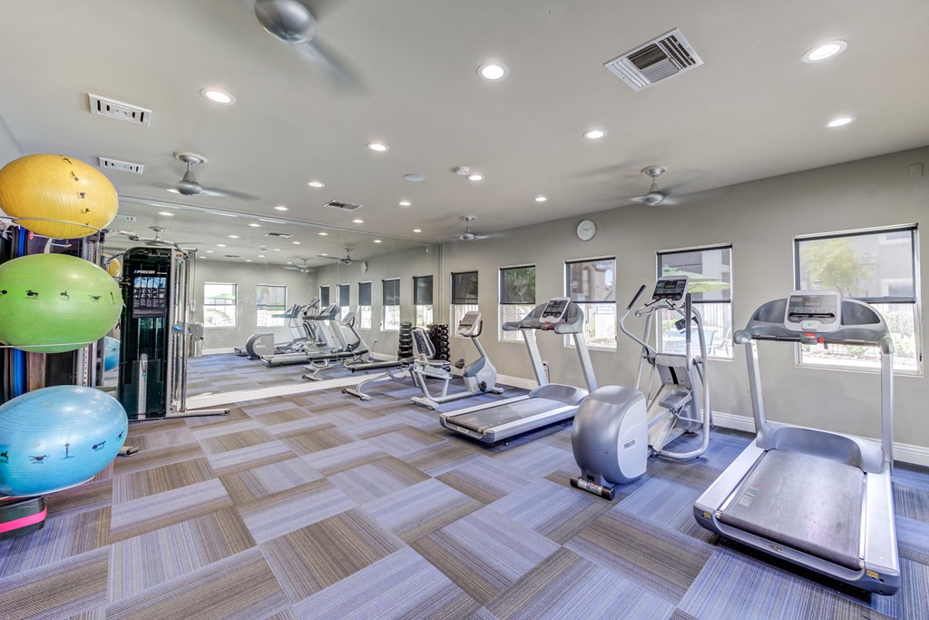 a spacious fitness center with treadmills and other exercise equipment