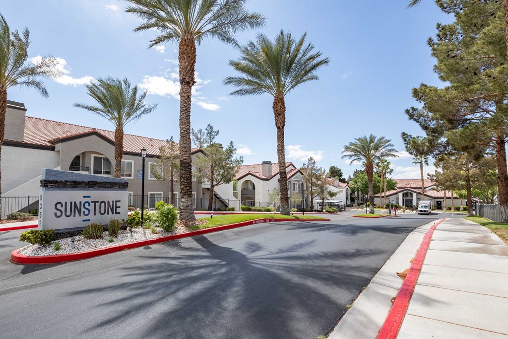 a street with palm trees and houses in the background