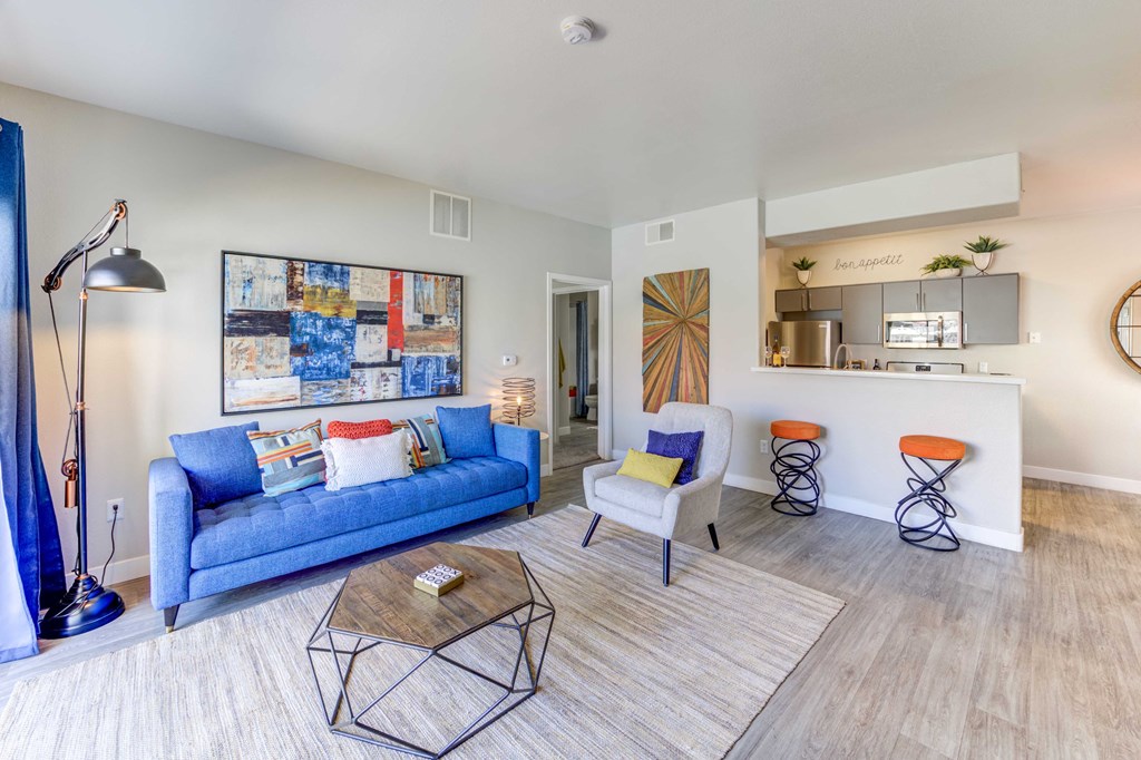 a living room with a blue couch and two chairs