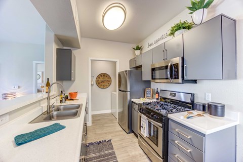 a kitchen with stainless steel appliances and a sink and a stove