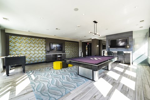 A room with a pool table and a television.