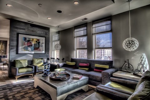 A living room with a grey sofa, a green chair and a coffee table.