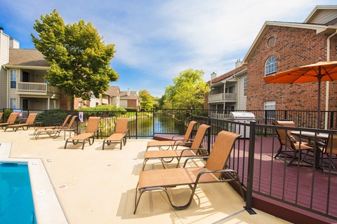 A pool area with chairs and a table.
