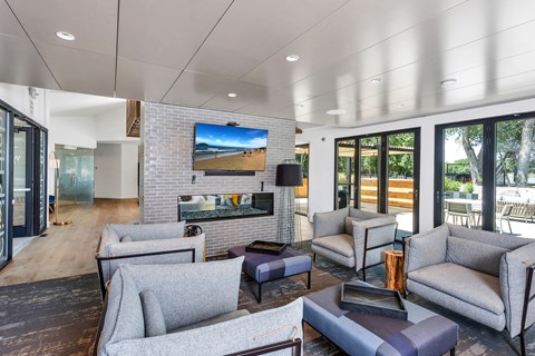 A modern living room with grey couches and a flat screen TV mounted on the wall.