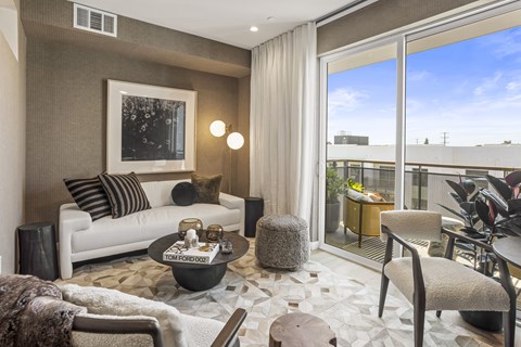 A living room with a white couch, a coffee table, and a painting on the wall.